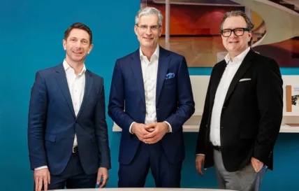 Drei Geschäftsführer in blauen Anzügen stehen zusammen