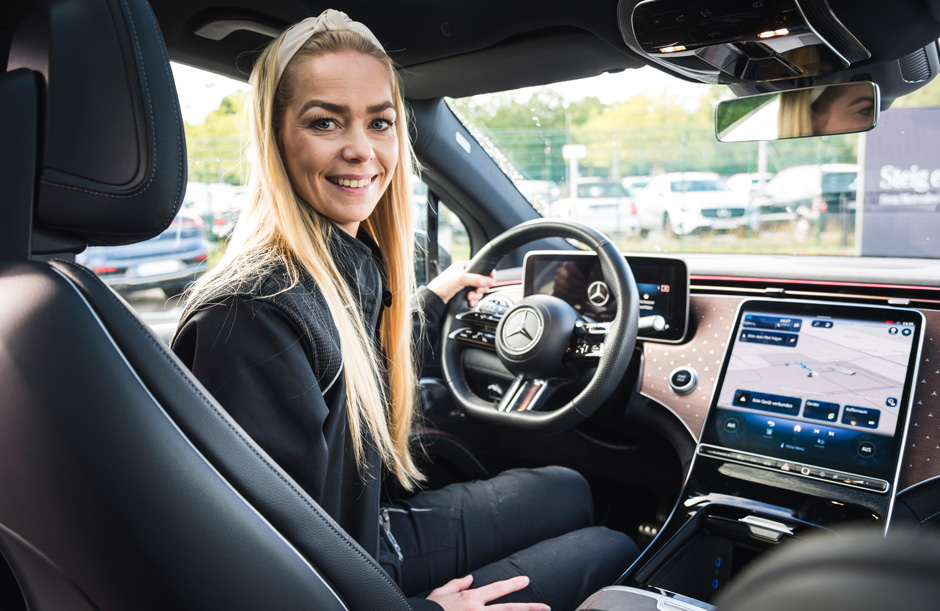Frau sitzt am Steuer eines Wagens, Innenraum