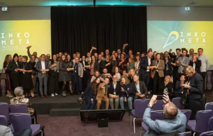 Menschen jubeln auf einer Bühne mit Pokalen