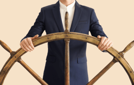 Mann mit Schlips steht am Ruder